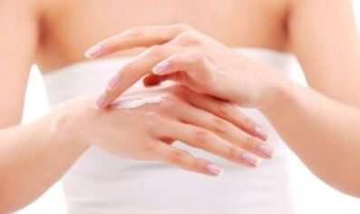 Mädchen trägt Salbe auf ihre Hand auf